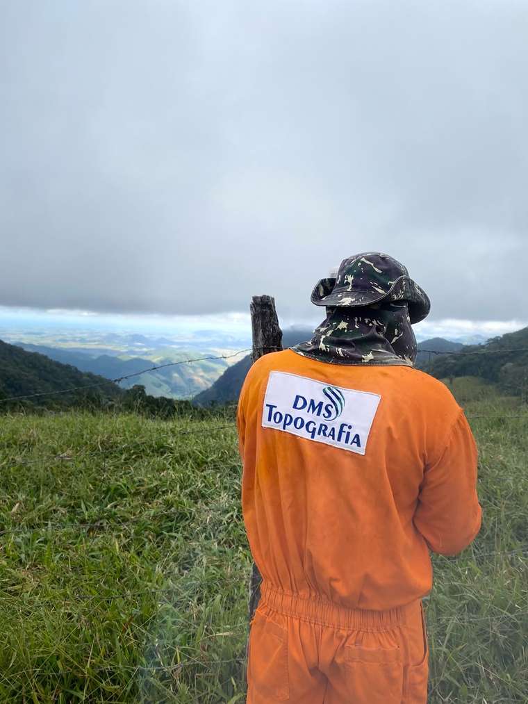 Profissional da DMS em campo, em meio à paisagem da região serrana