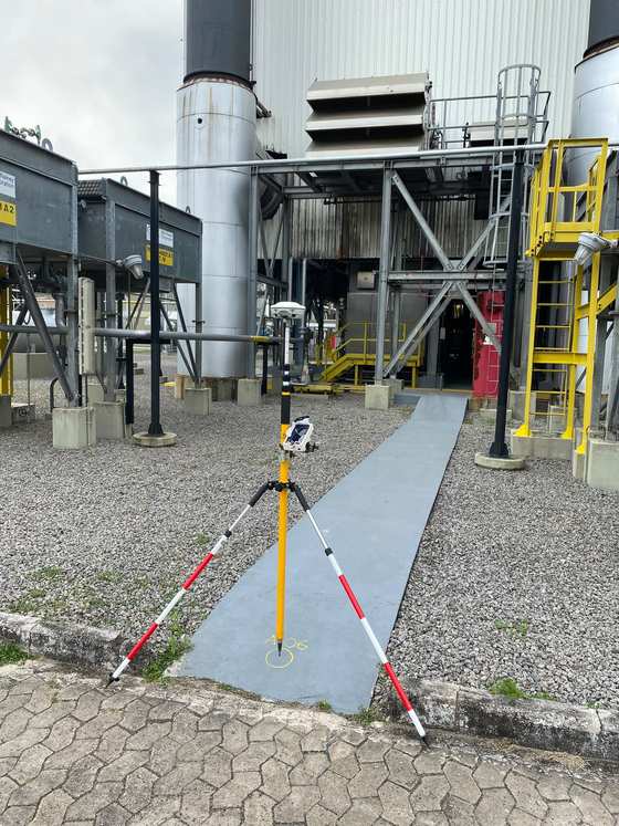 Equipamento topográfico instalado em ambiente industrial para levantamento de pontos de apoio